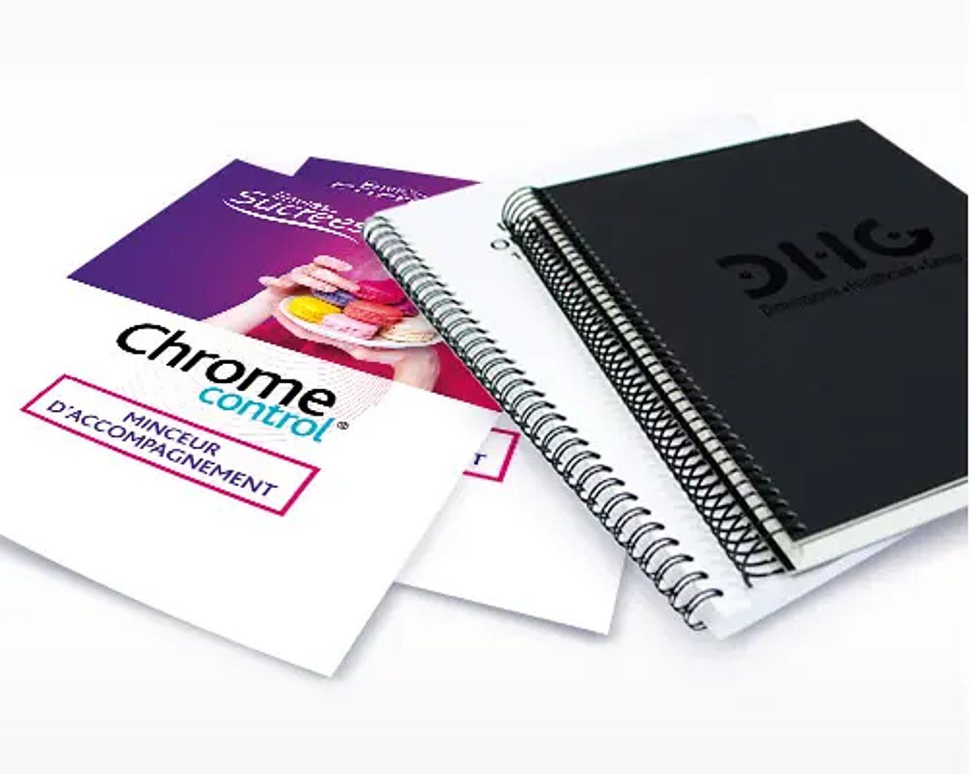Des carnets à spirale noirs et blancs posés à côté de flyers imprimés, dont un Chrome Control « minceur d'accompagnement », sur fond blanc.
